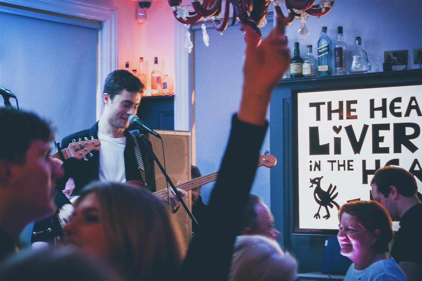 Patrick singing and playing bass on stage in a bar